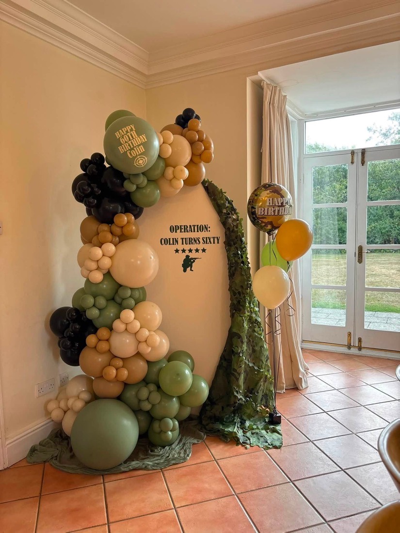 Organic garland in sage green, chocolate brown and gold framing a 60th birthday sign