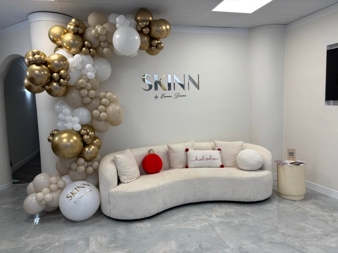 Gold, white and ivory balloon garland arching over a salon lounge